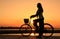 Silhouetted woman with bicycle at Mekong river