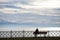 Silhouetted woman sitting on bench at lake constance