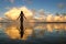 Silhouetted woman standing in a water at sunset on Taveuni Island, Fij