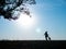 Silhouettes of adorable woman playing running with her cute dog during sunset