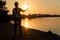 Silhouettes of asian woman engineer holding wrenches and standing on shipyard and background is oil storage silo. Concept of women