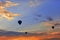 Silhouettes of balloons on the background of the morning sky with fiery red clouds