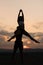 Silhouettes of beautiful mixed gymnastic couple dancing on sunset. Grace and beauty of human\'s body