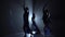 Silhouettes of beautiful slim figures dancing on black background, studio