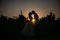 Silhouettes bride groom standing on the vineyard and tenderly looking at each other at sunset. Concept of love and