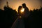 Silhouettes bride groom standing on the vineyard and tenderly looking at each other at sunset. Concept of love and