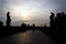 Silhouettes Charles Bridge, Old Town Tower, statues and happy tourists at sunrise, Prague, Czech Republic