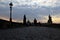 Silhouettes Charles Bridge, Old Town Tower, statues and happy tourists at sunrise, Prague, Czech Republic