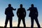 Silhouettes of company leaders standing on sunset sky background.