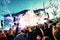 Silhouettes of concert crowd in front of bright stage lights