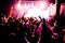 Silhouettes of concert crowd in front of bright stage lights with confetti