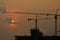 Silhouettes construction cranes with sunsets