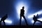 Silhouettes of cool rock band musicians on stage.