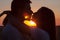 Silhouettes of couple kissing at summer sunset