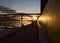 Silhouettes of couple running at beautiful, early dawn under a bridge.