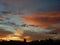 Silhouettes of distant buildings under dramatic large sky at dawn break