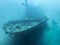 Silhouettes of divers over a sunken ship at the bottom of the Indian Ocean