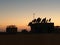 Silhouettes of electrical substations with cables on the roofs at golden sunset