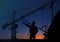 Silhouettes of engineer and construction crane