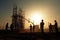 Silhouettes of engineers at construction site at sunset. Generative AI