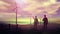 Silhouettes of engineers watching wind farms at sunset.