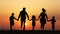 Silhouettes of family holding the hands and running in the meadow during sunset.