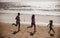 Silhouettes of family jogging along sea beach at sunrise. Outdoor workout, silhouettes of runners, sport and healthy