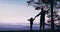 Silhouettes of father with baby daughter standing on the edge, holding hands and enjoying the distant mountain ranges in morning l