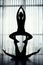 Silhouettes of female Acroyogis practicing straddle throne