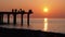 Silhouettes of Fishermen with Fishing Rods at Sea Sunset Sitting on the Pier. Slow Motion.
