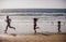 Silhouettes of fitness family running near sea. Family jogging for sport for fitness outdoors with child.