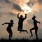 Silhouettes of friends jumping outdoor