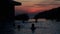 Silhouettes of girls swim in the infinity pool overlooking the sunset