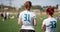 Silhouettes of girls watching the match at the stadium. flag football competitions among female teams. Blue flag flying