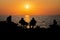 Silhouettes of a group of friends resting at the beach on beautiful sunset