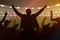 Silhouettes of happy cheerful sport fans at stadium