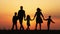 Silhouettes of happy family walking together in the meadow during sunset