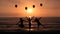 Silhouettes Of Happy Girls Jumping On the Sunset Beach Enjoying life Together With Party Balloons. Holidays and Happiness concept