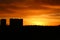 Silhouettes of high-rise buildings and a forest against a beautiful fiery red sunset