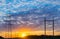 Silhouettes high voltage electric pylon in sunset background