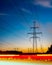 Silhouettes high voltage electric pylon in sunset background