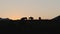 Silhouettes of horses against the sunset in a pasture in the mountains. The concept of pets in the wild