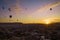 Silhouettes of hot air balloons at sunrise in Cappadocia, Turkey - Sun coming up as balloons rise at dawn. Light is coming in