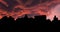 Silhouettes of houses and roofs against the sunset.