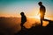 Silhouettes of little boy and girl hiking at sunset mountains