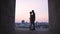 Silhouettes of lovers hugging against background of sunset on horizon, romance