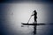Silhouettes of man canoeing in calm water