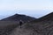 A silhouettes of a man hiking on a slope of Etna - the highest active volcano in Europe