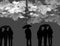 Silhouettes of many people holding opened umbrellas against cloudy sky and  lightning. Rainy weather thunderstorm forecast.