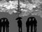 Silhouettes of many people holding opened umbrellas against cloudy sky and  lightning. Rainy weather thunderstorm forecast.